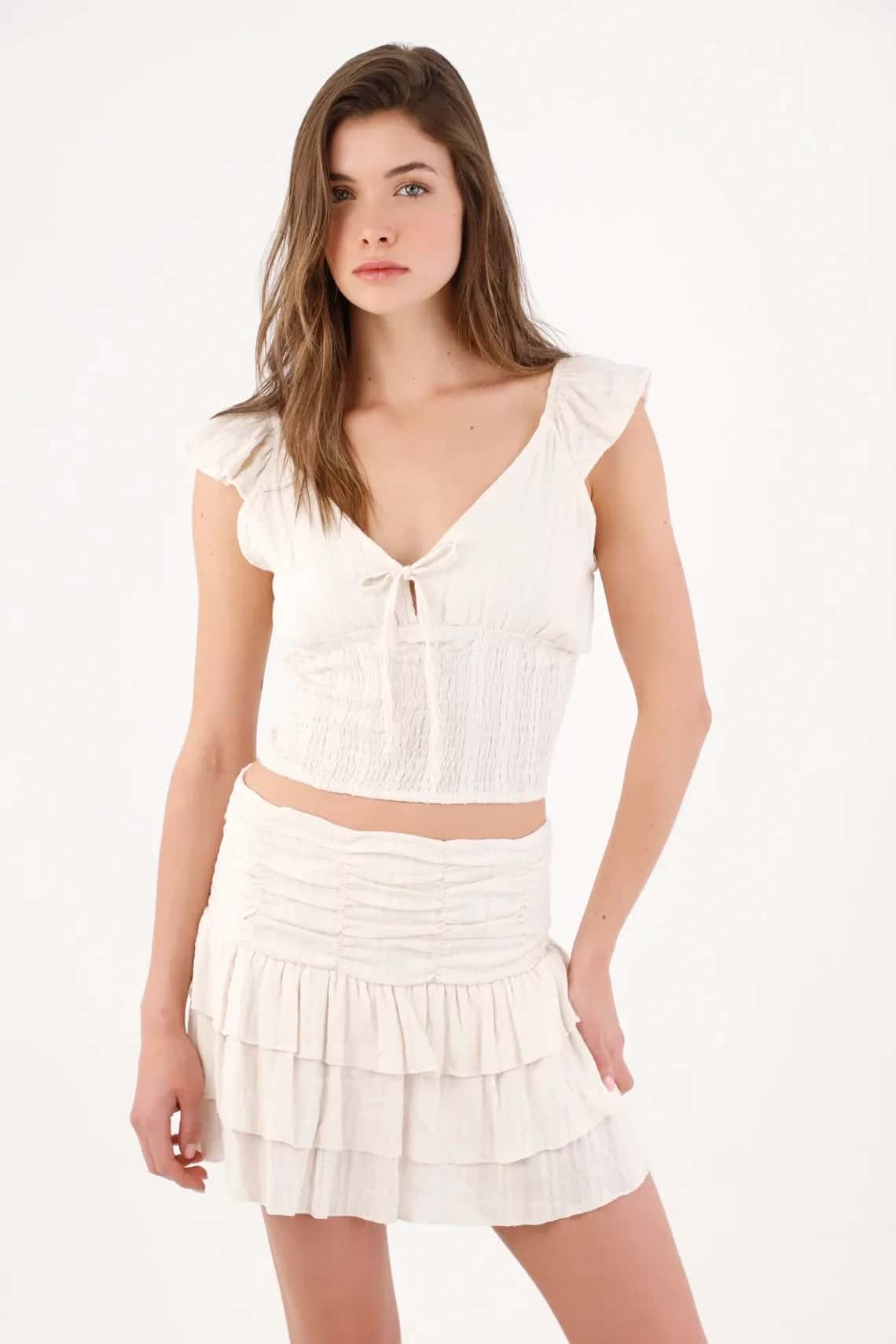 Blusa cropped entallada con lazo y nido de abeja en algodón crudo para mujer